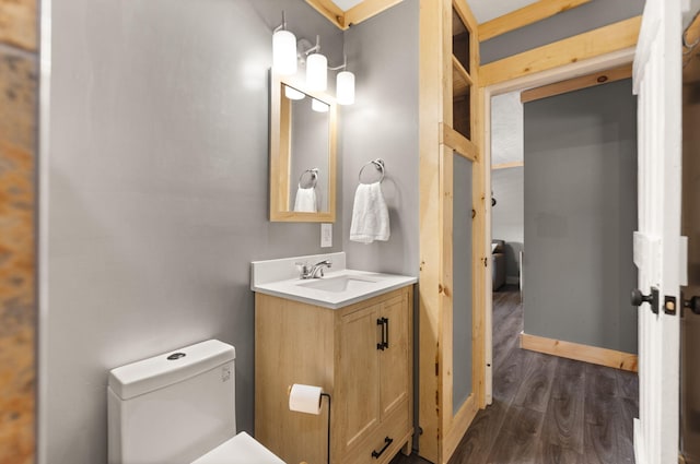 bathroom with hardwood / wood-style flooring, toilet, and vanity