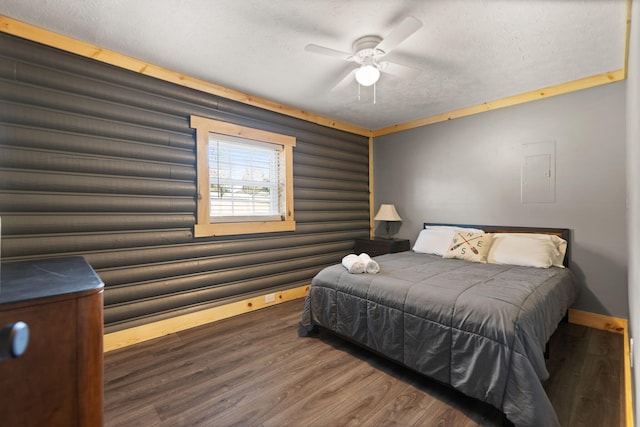 bedroom featuring ceiling fan, dark hardwood / wood-style floors, and a textured ceiling