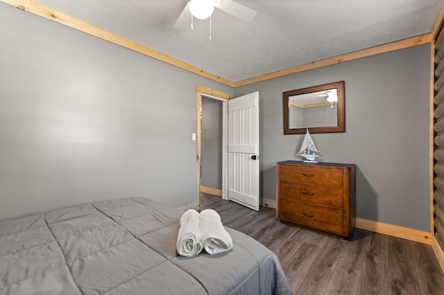 bedroom with ceiling fan, crown molding, and hardwood / wood-style flooring