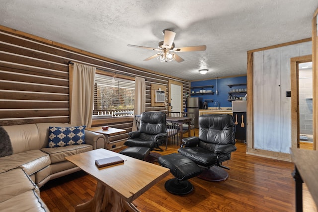 living room featuring wooden walls, ceiling fan, dark hardwood / wood-style floors, a wall mounted air conditioner, and a textured ceiling