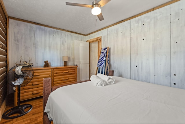 bedroom featuring ceiling fan, rustic walls, and wood walls