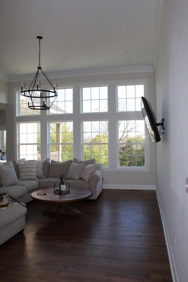 living room with ornamental molding, dark wood-type flooring, and a notable chandelier