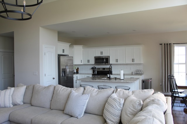 living room with hardwood / wood-style flooring, a chandelier, and sink