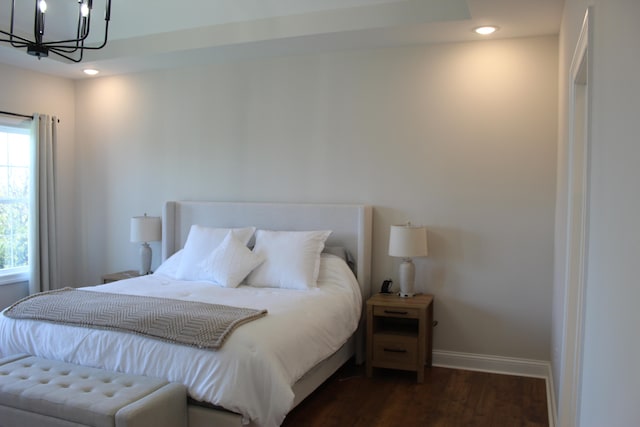 bedroom featuring dark hardwood / wood-style floors and a chandelier