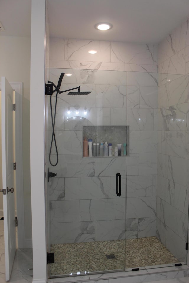 bathroom featuring a shower with door