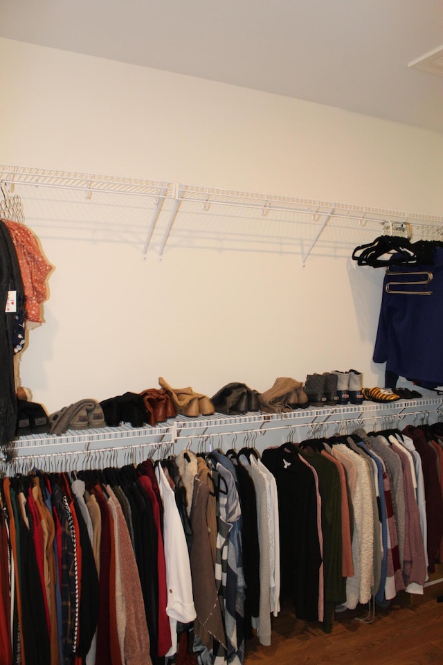 spacious closet with dark hardwood / wood-style flooring