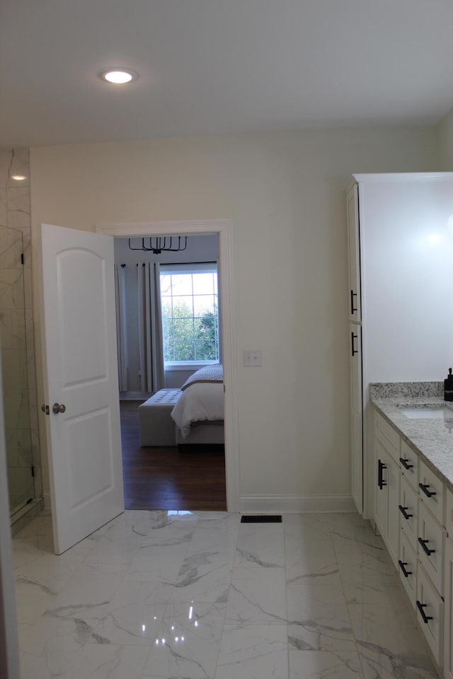 bathroom featuring walk in shower and vanity