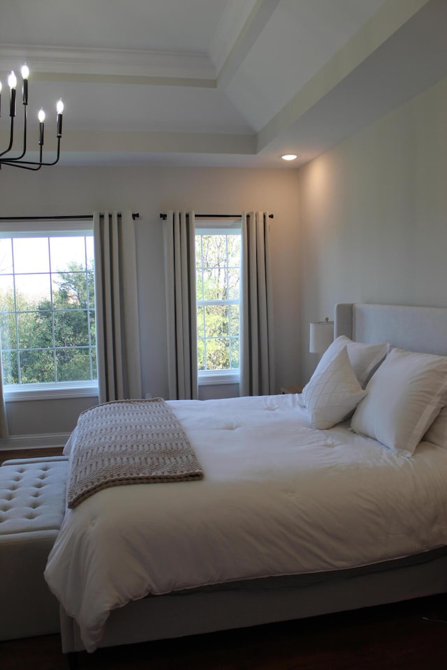 bedroom with dark hardwood / wood-style flooring, a chandelier, ornamental molding, and a raised ceiling