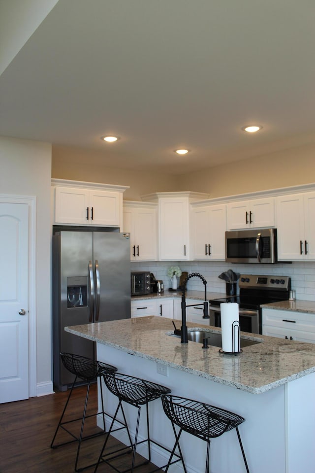 kitchen with dark wood-type flooring, white cabinetry, sink, and stainless steel appliances