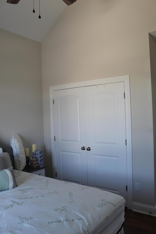 bedroom with dark hardwood / wood-style flooring, a closet, and vaulted ceiling