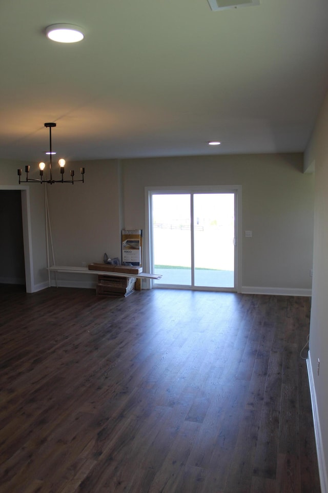 unfurnished room with dark hardwood / wood-style flooring and a chandelier