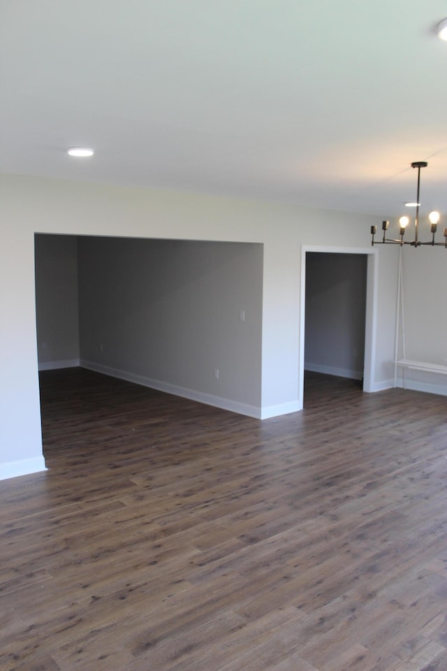 empty room featuring dark hardwood / wood-style floors and a chandelier