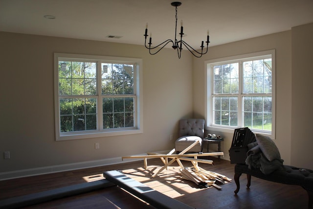 sitting room with a wealth of natural light, a notable chandelier, and hardwood / wood-style flooring