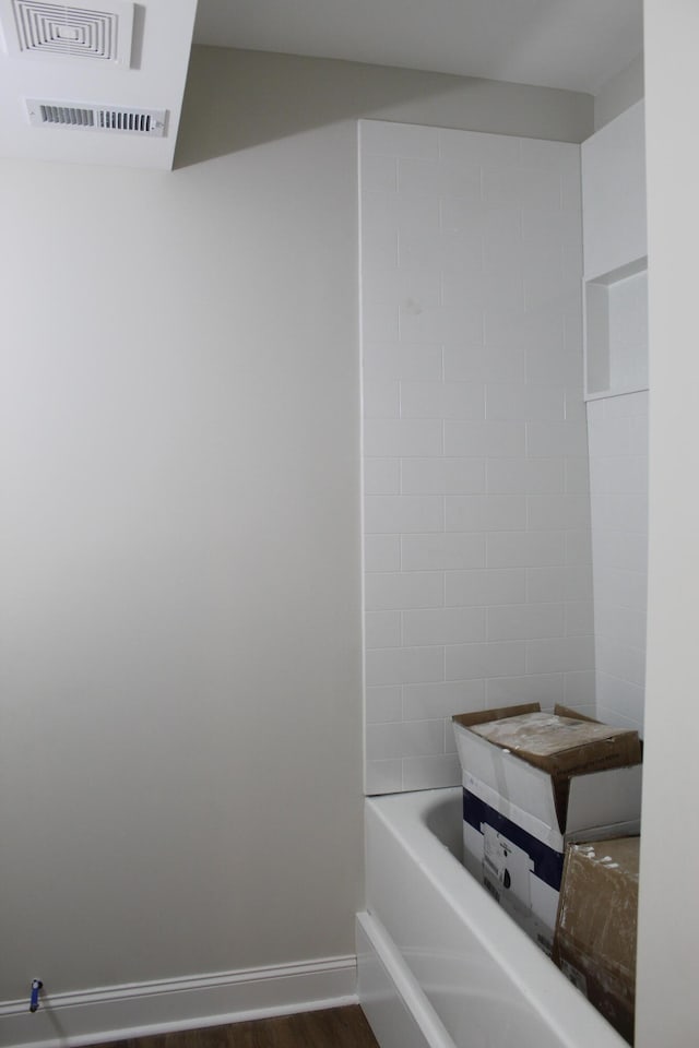 bathroom with a bath and wood-type flooring