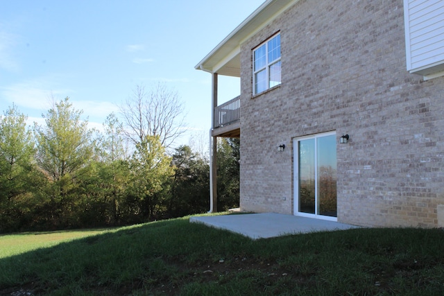 exterior space featuring a balcony, a lawn, and a patio