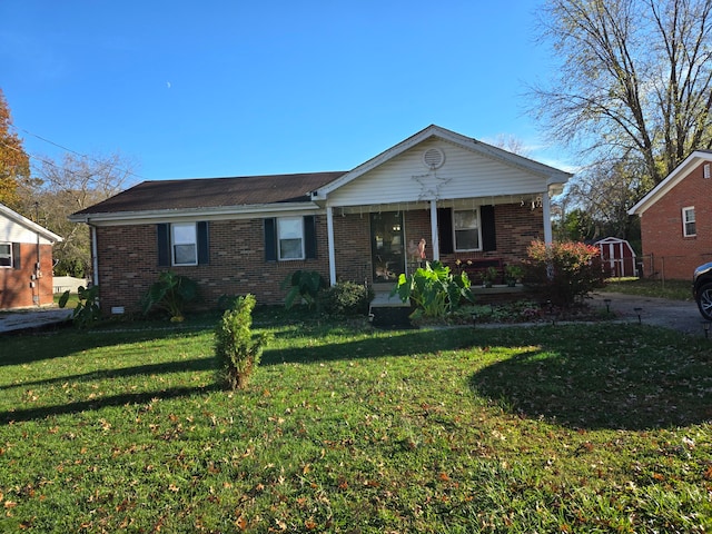 view of front facade featuring a front yard and a storage shed