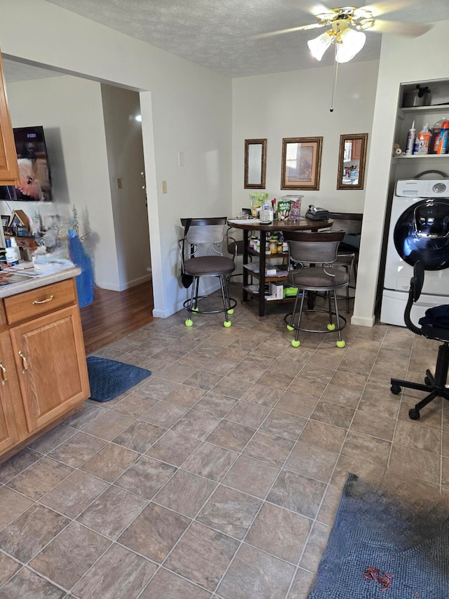 office area featuring a textured ceiling, hardwood / wood-style flooring, ceiling fan, and washer / dryer