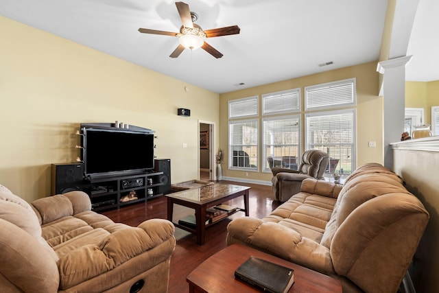 living area with visible vents, baseboards, decorative columns, wood finished floors, and a ceiling fan