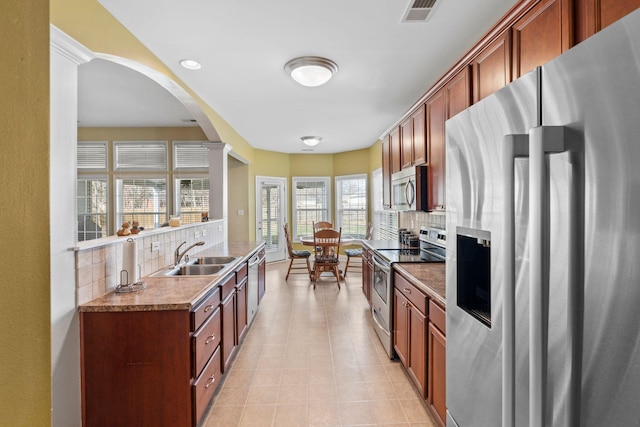 kitchen with a sink, visible vents, backsplash, and appliances with stainless steel finishes