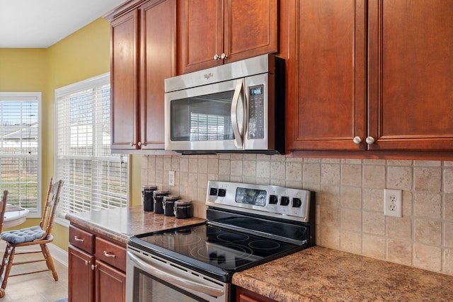 kitchen with decorative backsplash, stainless steel appliances, and baseboards