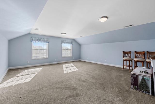 additional living space featuring visible vents, baseboards, carpet floors, and vaulted ceiling