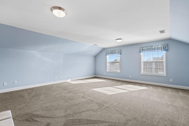 additional living space with lofted ceiling, baseboards, visible vents, and carpet floors