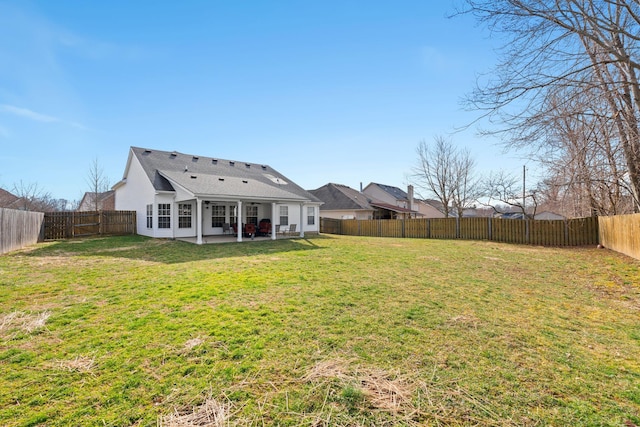 rear view of house with a patio, a yard, and a fenced backyard