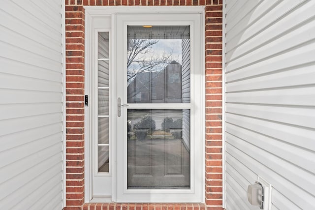 view of exterior entry featuring brick siding