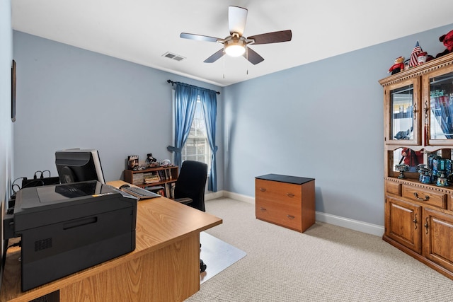 office space with visible vents, baseboards, light carpet, and a ceiling fan