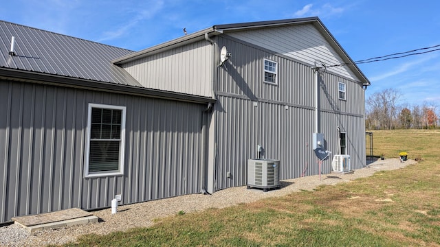 view of side of property featuring central AC and a yard