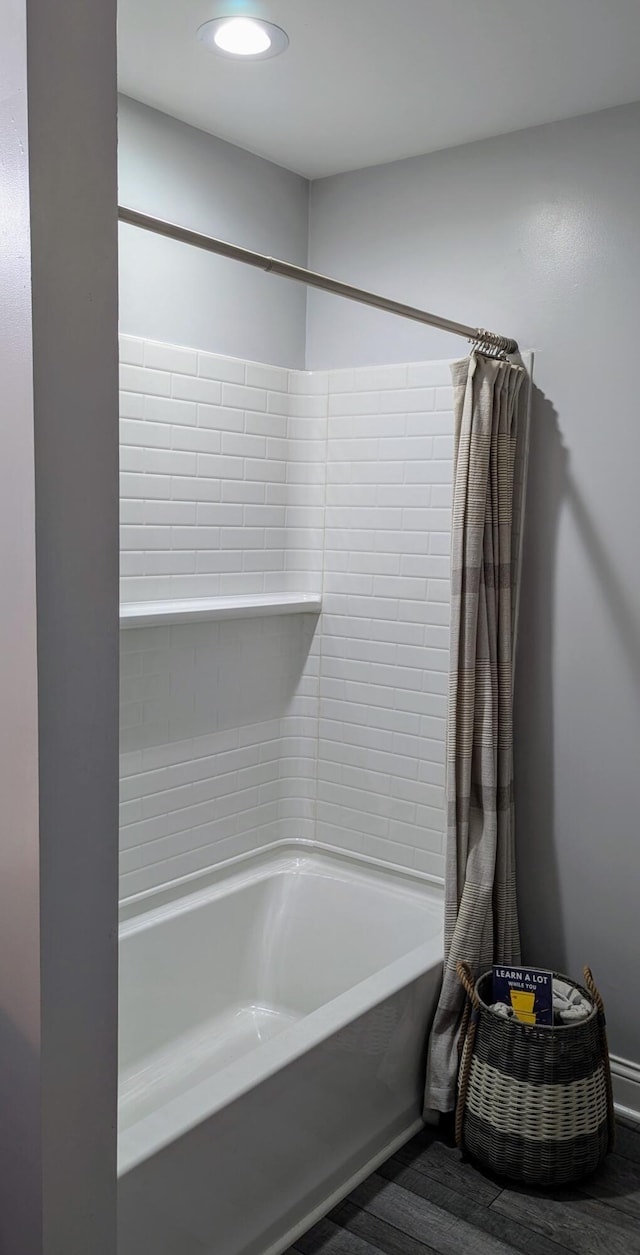 bathroom featuring hardwood / wood-style flooring and shower / bath combination with curtain