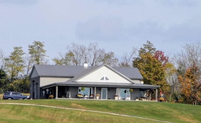 back of property featuring covered porch and a yard