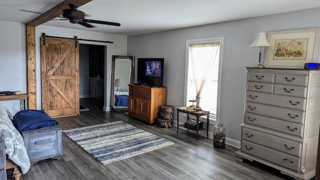 sitting room with dark hardwood / wood-style flooring, a barn door, and ceiling fan