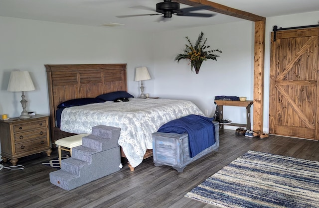 bedroom with dark hardwood / wood-style flooring, a barn door, and ceiling fan