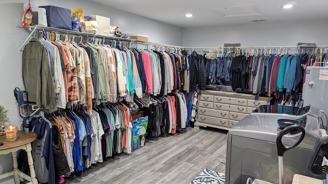 spacious closet featuring light hardwood / wood-style flooring and washing machine and clothes dryer