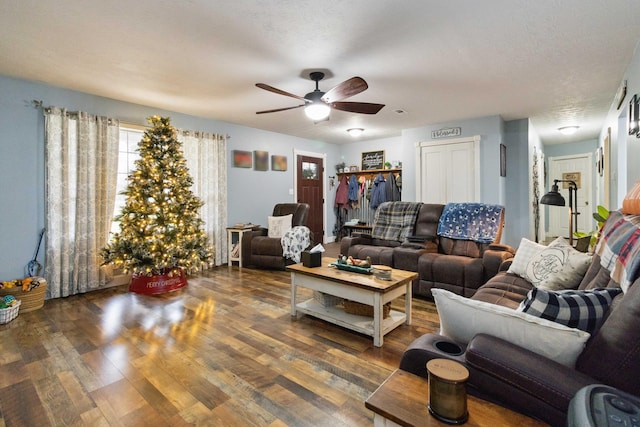 living room with dark hardwood / wood-style flooring, a textured ceiling, and ceiling fan