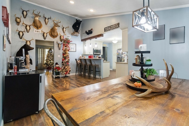 dining area with dark wood-type flooring, ornate columns, lofted ceiling, and ornamental molding