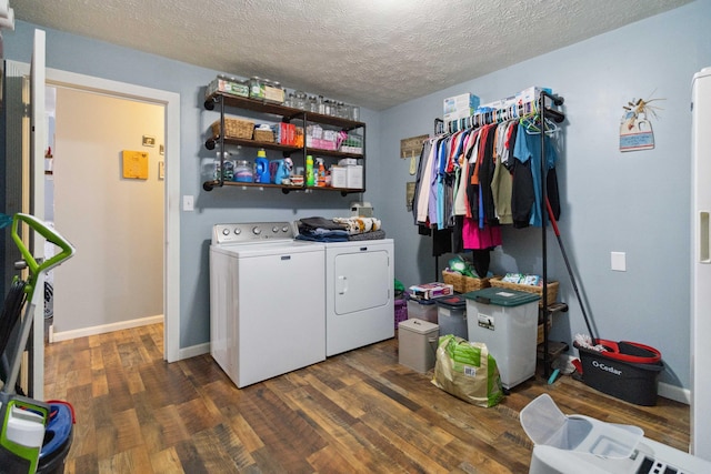 clothes washing area with dark wood-type flooring, a textured ceiling, and separate washer and dryer