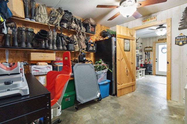 office area with a barn door, ceiling fan, and concrete floors