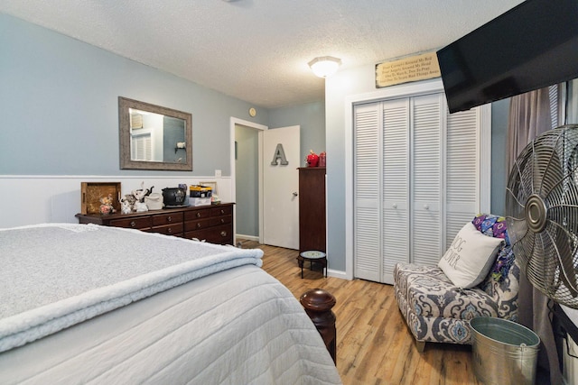 bedroom featuring a textured ceiling, a closet, and light wood-type flooring