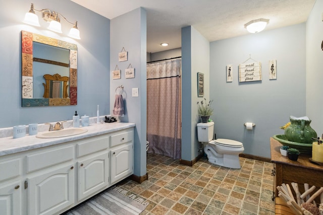 bathroom featuring curtained shower, vanity, toilet, and a textured ceiling