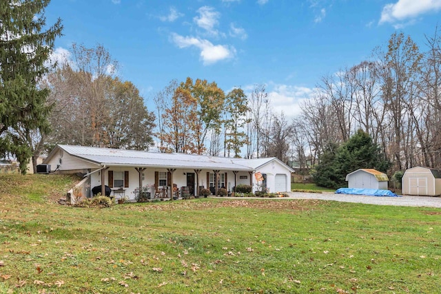 ranch-style home with a garage, a shed, a front yard, and a porch