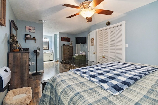 bedroom with ensuite bath, ceiling fan, dark hardwood / wood-style floors, a textured ceiling, and a closet