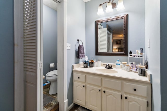 bathroom featuring vanity and toilet