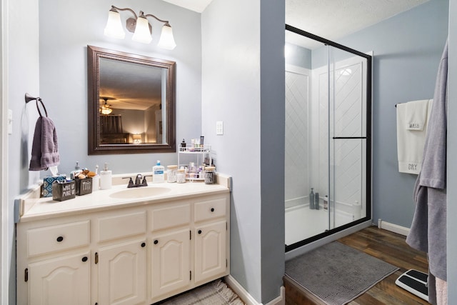 bathroom featuring wood-type flooring, a textured ceiling, vanity, and a shower with door