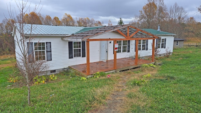 view of front facade with a front lawn and a wooden deck