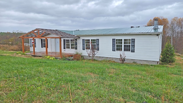 back of property with a wooden deck and a lawn