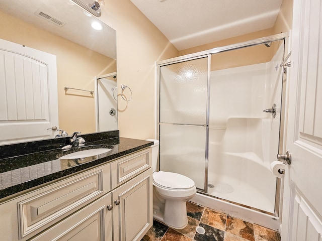 bathroom with vanity, a textured ceiling, toilet, and a shower with door