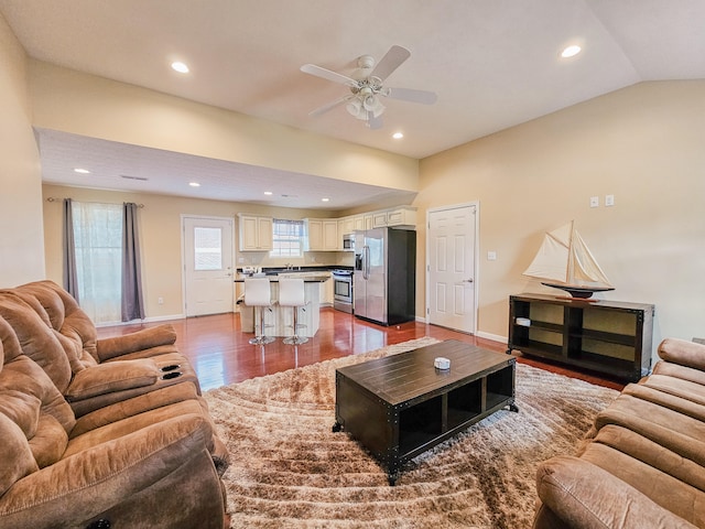 living room featuring wood-type flooring, ceiling fan, and vaulted ceiling