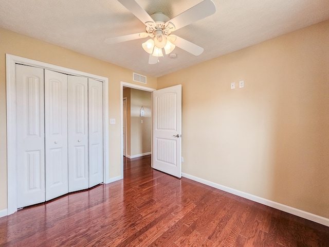 unfurnished bedroom featuring a closet, wood-type flooring, ceiling fan, and a textured ceiling